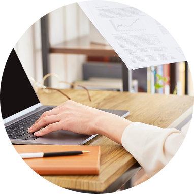 書類を確認しながらパソコンで作業を行う様子